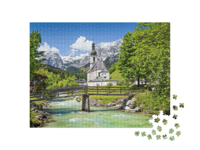 Puzzle 1000 pezzi „Pittoresco paesaggio montano con la chiesa parrocchiale di San Sebastiano nel villaggio di Ramsau“