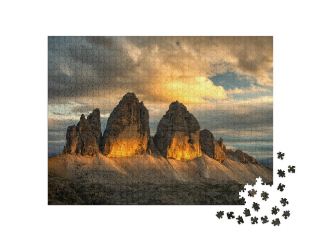 Puzzle 1000 pezzi „Il famoso massiccio roccioso delle Tre Cime al tramonto con le nuvole colorate sopra le cime“
