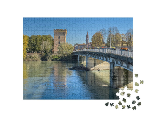 Puzzle 1000 pezzi „Ponte che attraversa il fiume Adda a Pizzighetone, pittoresca cittadina in provincia di Cremona“