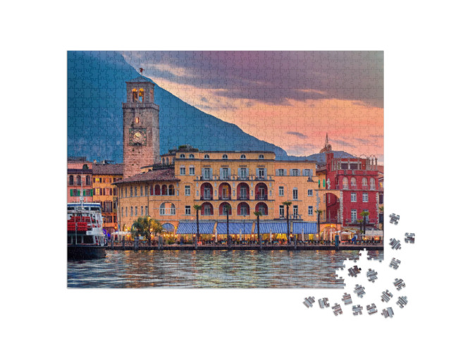 Puzzle 1000 pezzi „Vista della splendida città di Riva del Garda al tramonto con un cielo rosso“