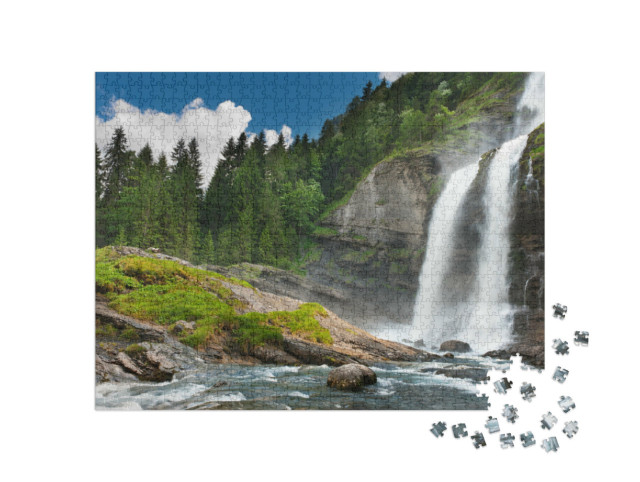 Puzzle 1000 pezzi „Cascata alpina nel bosco di montagna sotto un cielo blu“