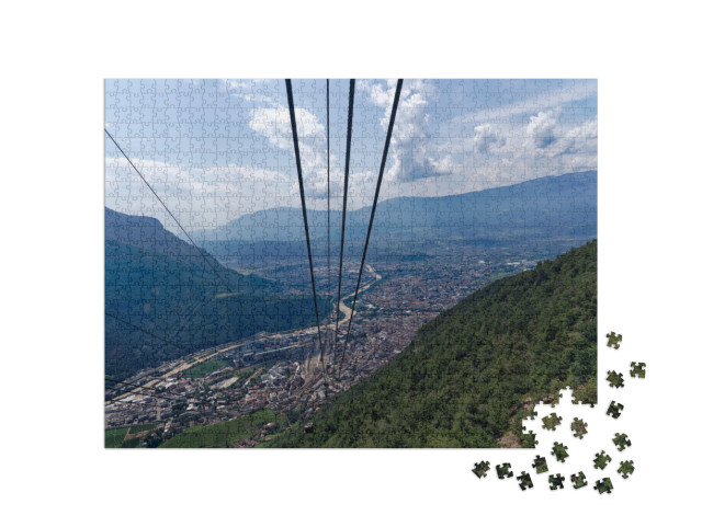 Puzzle 1000 pezzi „La funivia e la città di Bolzano con il suo pittoresco paesaggio in una soleggiata giornata estiva“