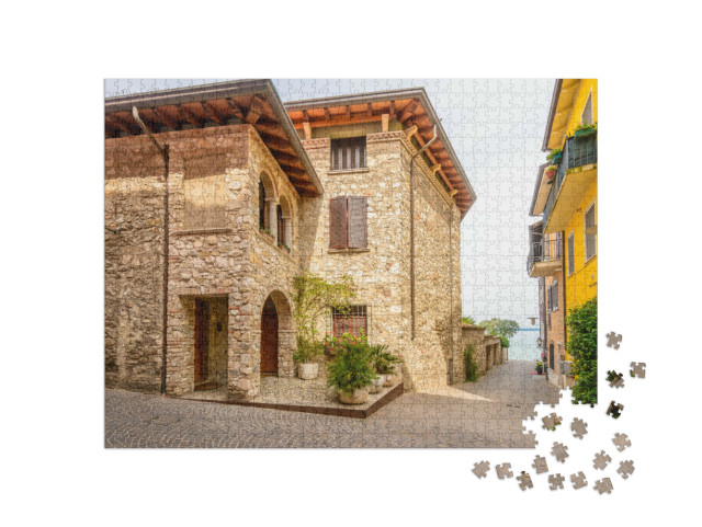 Puzzle 1000 pezzi „Vista della strada di una pittoresca cittadina a Sirmione, sul Lago di Garda.“
