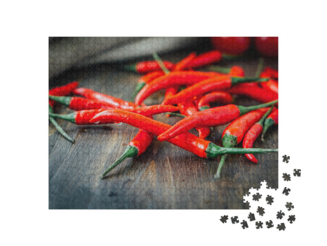 Puzzle 1000 pezzi „Peperoncini rossi su un tavolo di legno rustico“