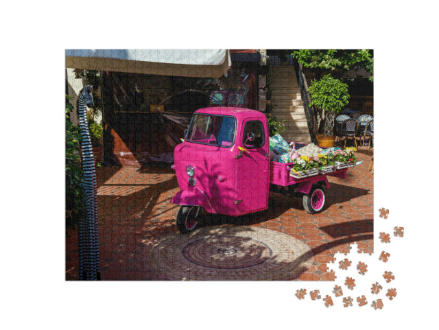 Puzzle 1000 pezzi „Piaggio Ape di colore rosa con fiori e oggetti in vendita nel bagagliaio“