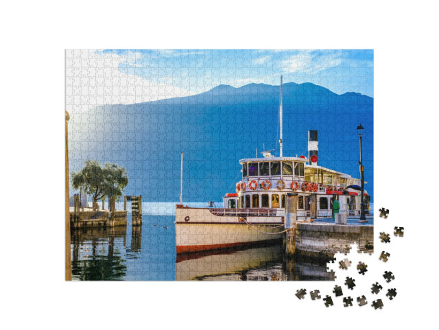 Puzzle 1000 pezzi „tipico traghetto passeggeri nel centro storico e nel porto di Riva del Garda“