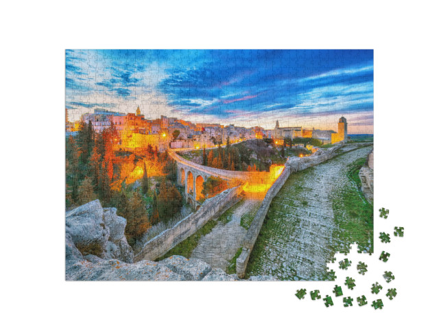 Puzzle 1000 pezzi „Favolosa vista di Gravina in Puglia: centro storico, ponte e gola all'alba“