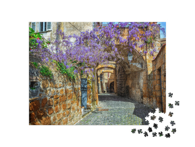 Puzzle 1000 pezzi „Stradina del centro storico di Orvieto, Umbria, Italia, decorata con fiori di glicine in fiore“