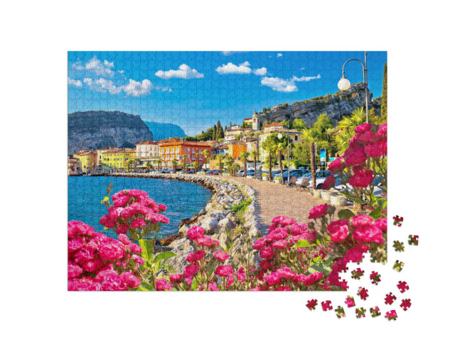 Puzzle 1000 pezzi „La colorata cittadina di Torbole, sul Lago di Garda, vista sul lungomare, Trentino Alto Adige“