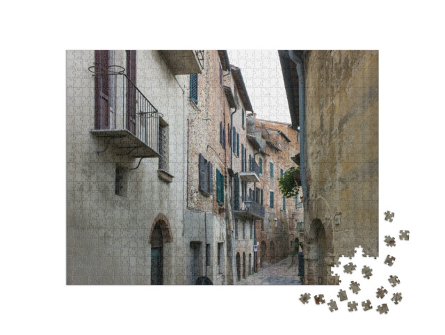 Puzzle 1000 pezzi „Vicolo stretto con vecchie case con balconi e persiane a Montepulciano, Italia“