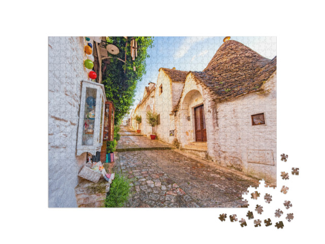 Puzzle 1000 pezzi „Trulli di Alberobello, Puglia, città di Alberobello con case a trulli tra piante verdi e fiori“