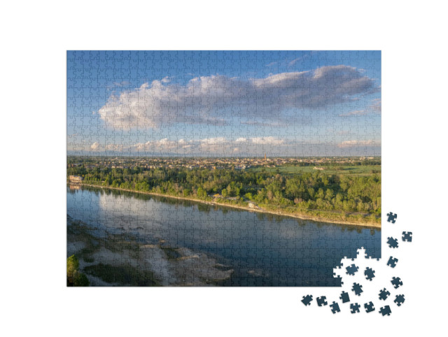 Puzzle 1000 pezzi „Riprese aeree con drone di Cremona e del fiume Po prima del tramonto, il ponte, la spiaggia, il parco“