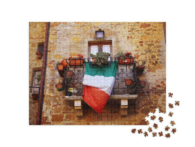 Puzzle 1000 pezzi „Tipico balcone italiano con bandiera e fiori a Montepulciano (Toscana)“