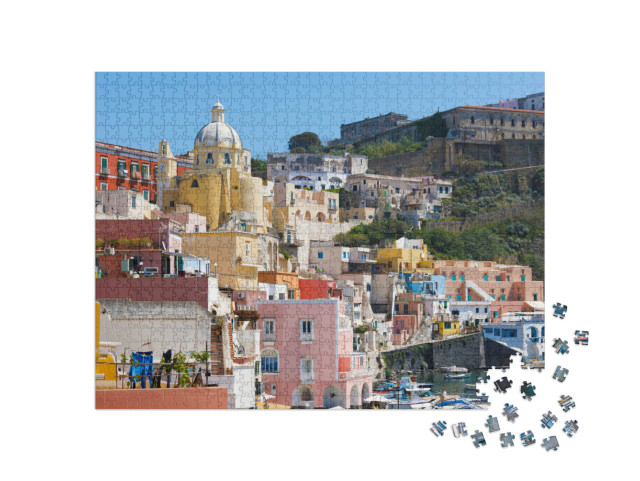 Puzzle 1000 pezzi „Vista del Santuario S. Maria delle Grazie Incoronata e delle case colorate sulla Corricella a Procida“
