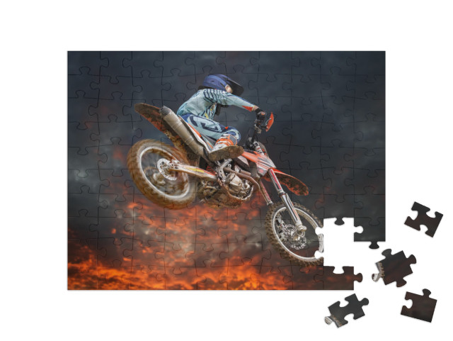 Puzzle 100 pezzi „Acrobazia di motocross sotto un cielo serale incandescente“