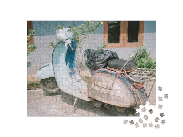Puzzle 1000 pezzi „Scooter Vespa d'epoca che presenta segni di usura e che evoca nostalgia e carattere in un contesto urbano“