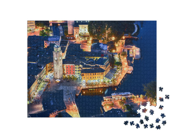 Puzzle 1000 pezzi „Vista del bellissimo lago di Garda .Riva del Garda città e lago di Garda di notte, Italia“