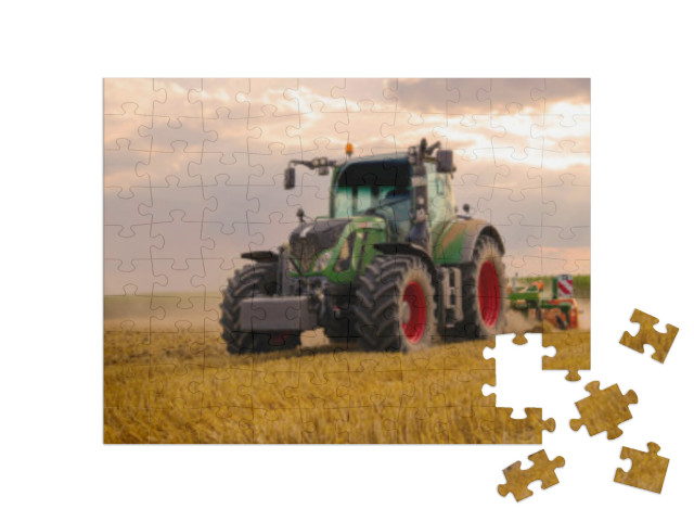 Puzzle 100 pezzi „Un trattore verde ara un campo di grano“