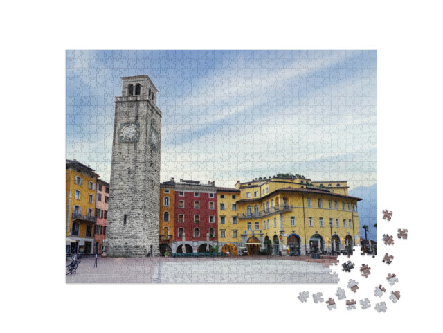 Puzzle 1000 pezzi „Riva del Garda, Italia. Centro storico e torre medievale Torre Apponale al mattino presto.“