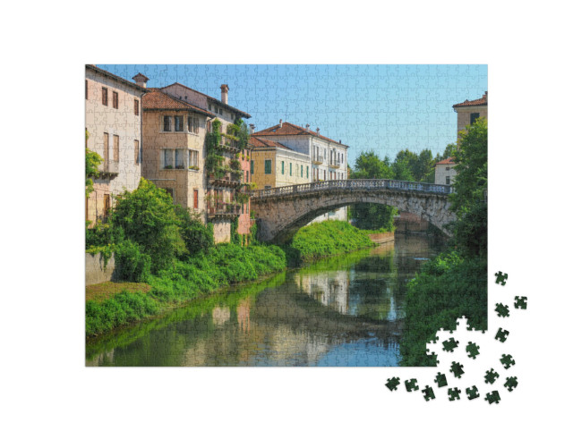 Puzzle 1000 pezzi „Storico ponte in pietra su un tranquillo canale a Vicenza, Italia“