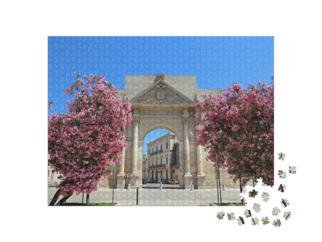 Puzzle 1000 pezzi „Lecce, Italia - città della penisola salentina. Arco di trionfo di Porta Napoli con fiori di oleandro.“