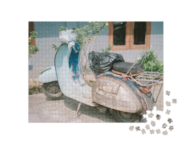 Puzzle 1000 pezzi „Scooter Vespa d'epoca che presenta segni di usura e che evoca nostalgia e carattere in un contesto urbano“