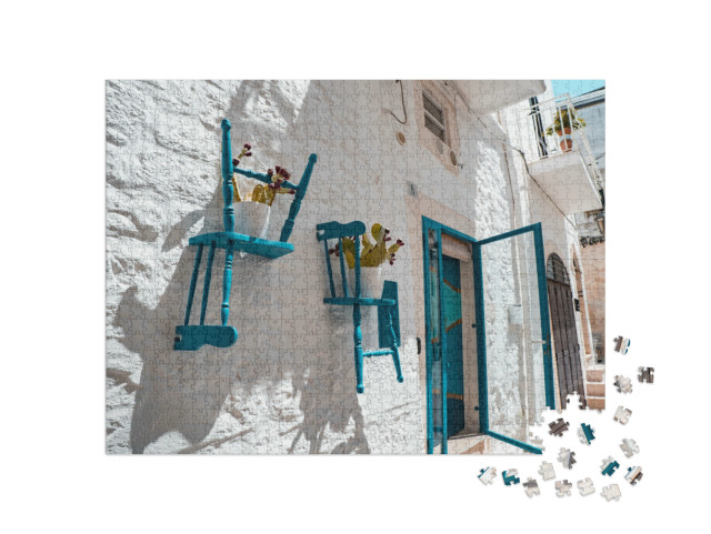 Puzzle 1000 pezzi „Tranquilla strada accogliente nella parte storica della città bianca di Ostuni, nel Sud Italia“