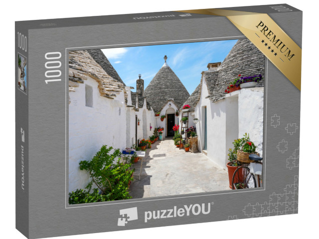 Puzzle 1000 pezzi „Fiori colorati di fronte alla tradizionale casa a trulli di Alberobello“