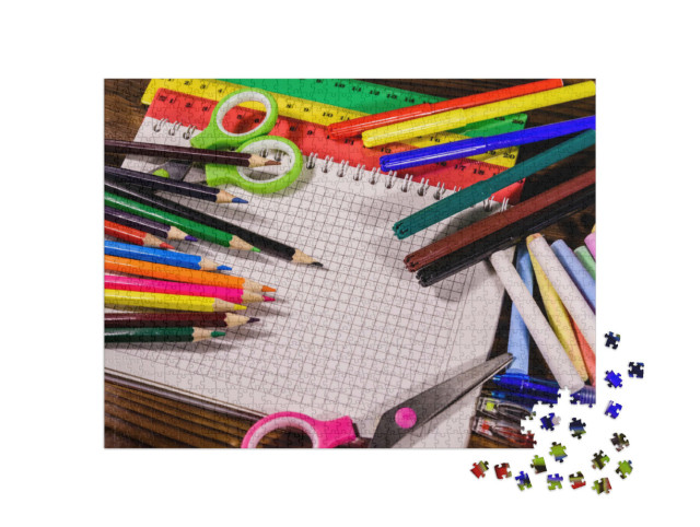Puzzle 1000 pezzi „Materiale scolastico su un tavolo di legno scuro“